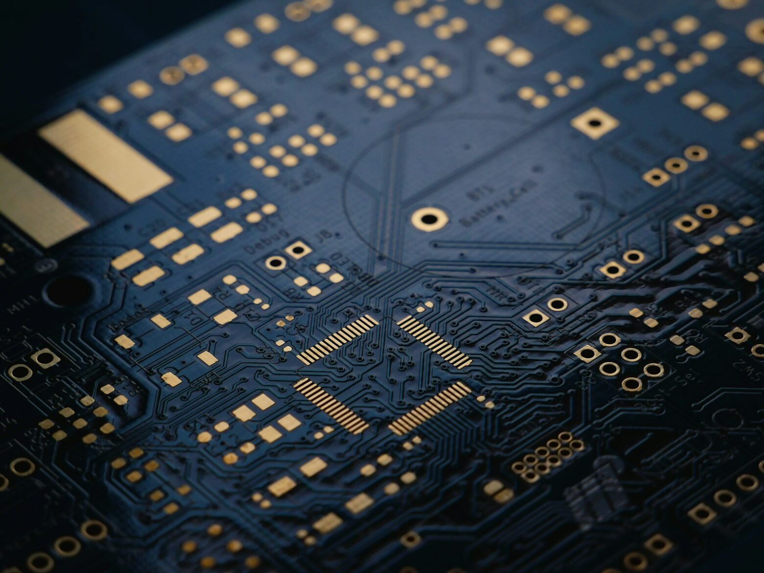 Macro view of a dark blue circuit board for embedded firmware engineering